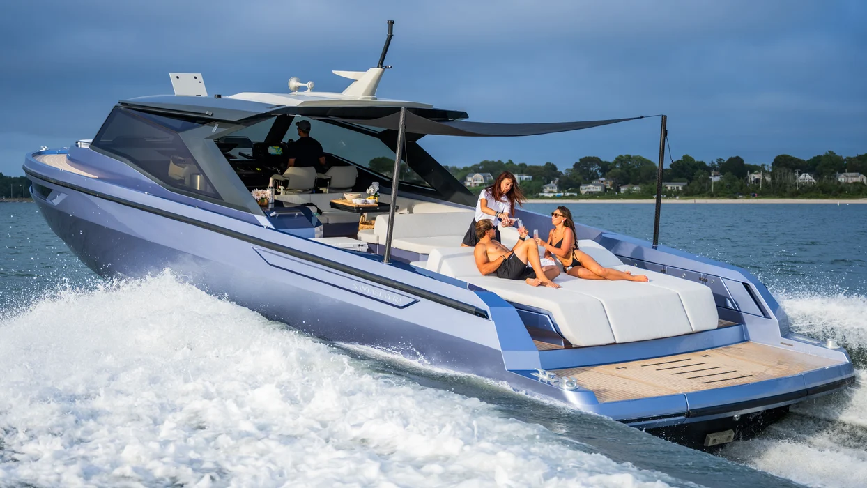 Guests celebrating birthday aboard sleek luxury yacht cruising coast.