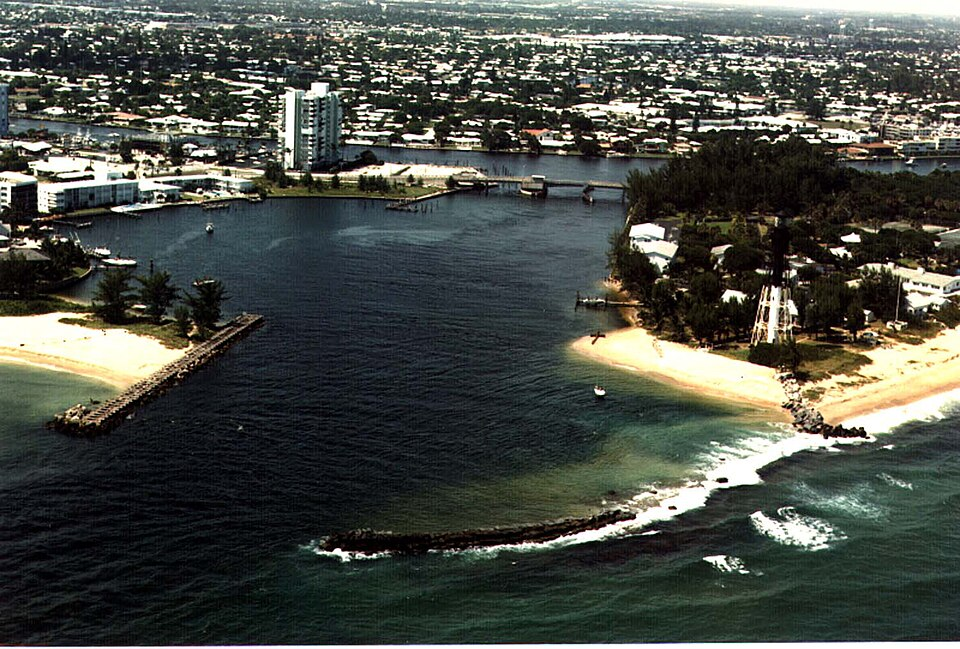 Hillsboro Inlet sandbar with lighthouse, jetty, and ocean waves.
