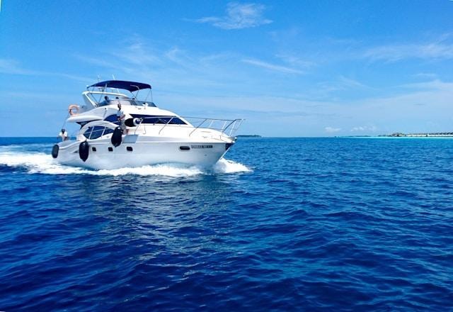 Private charter yacht cruises through calm blue ocean waters.