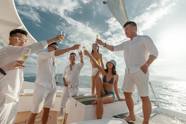 Yacht party with champagne toast under clear sunny sky.
