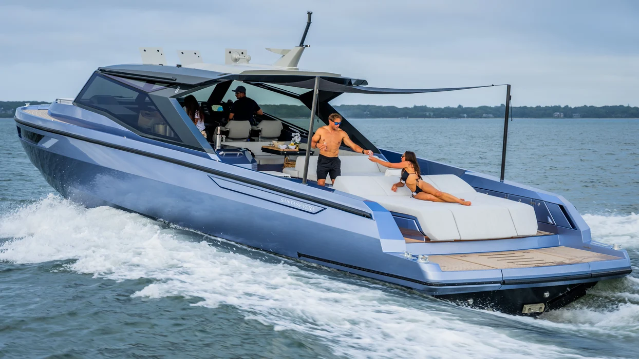 Luxury yacht charter cruising with guests relaxing on sun deck.