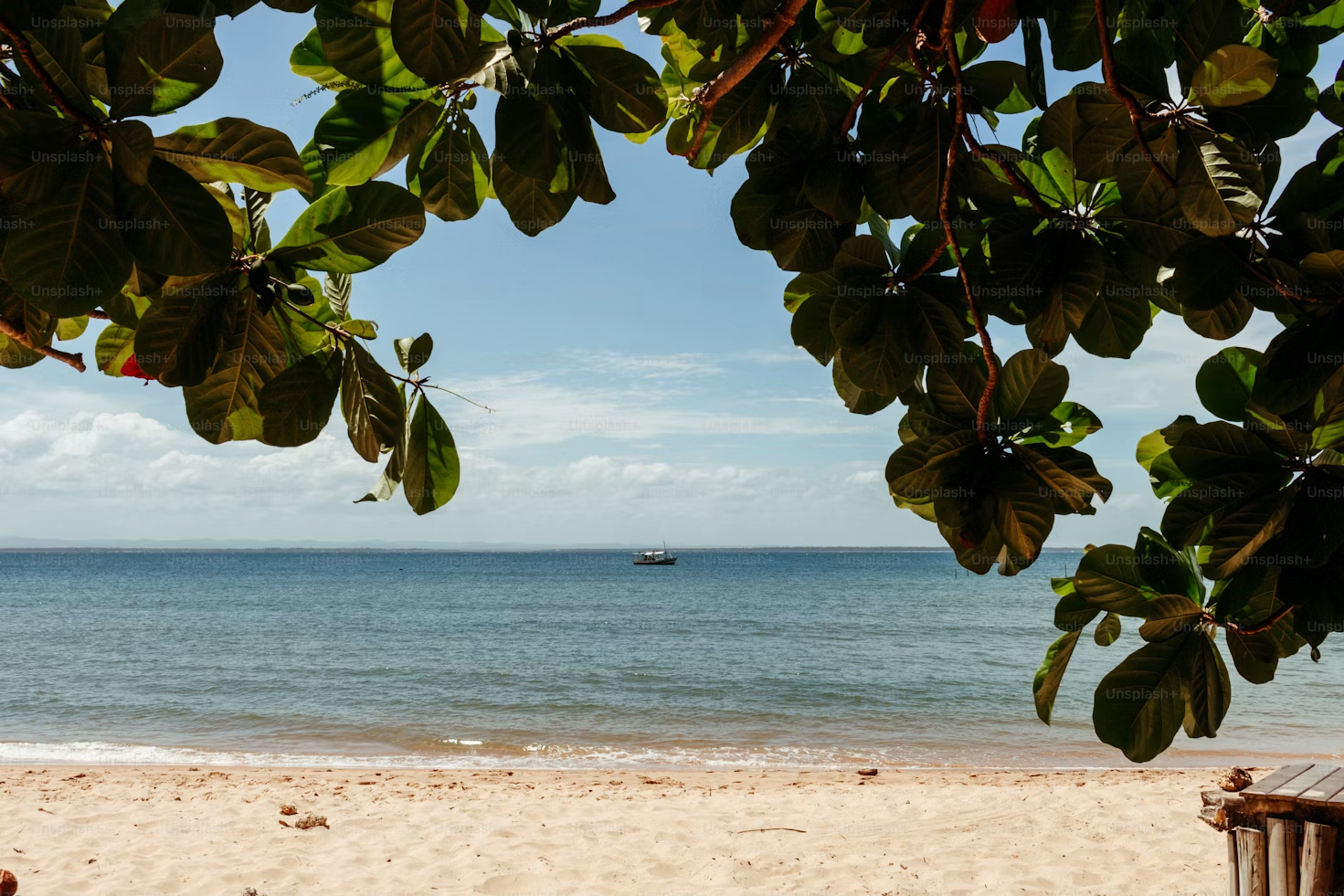 Fort Lauderdale beach with golden sand, calm ocean, and boat.