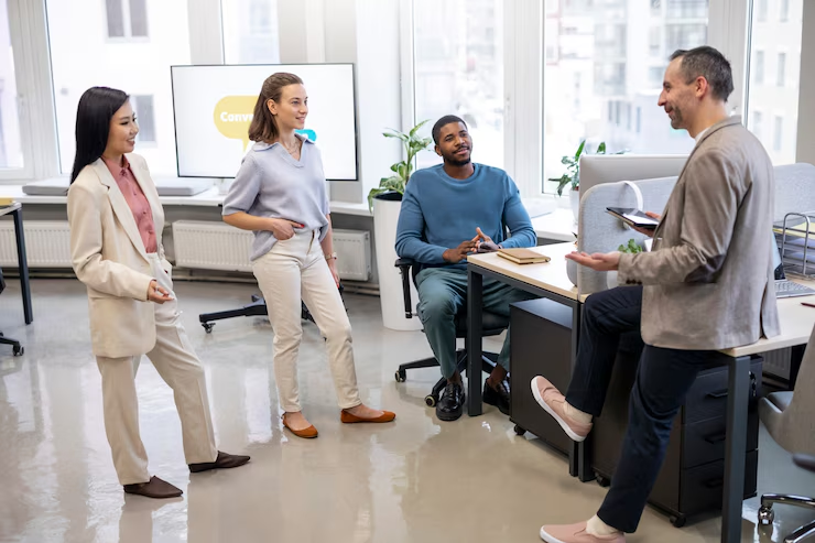 Colleagues talking and laughing together in their workplace