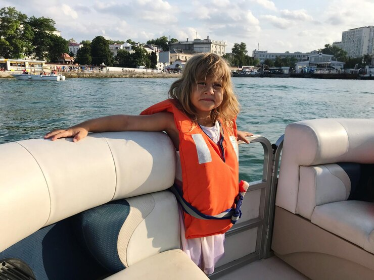 Little girl wearing a life jacket on a yacht