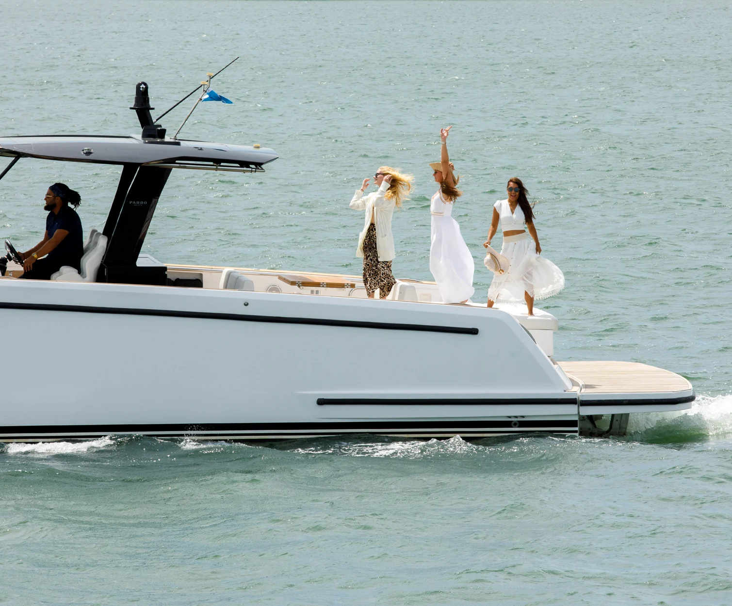Group celebrating bachelorette party on yacht under sunny skies.
