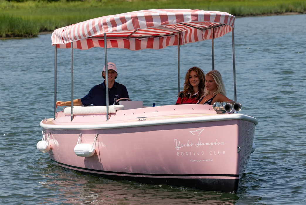 Family enjoying pastel boat rental with striped canopy.