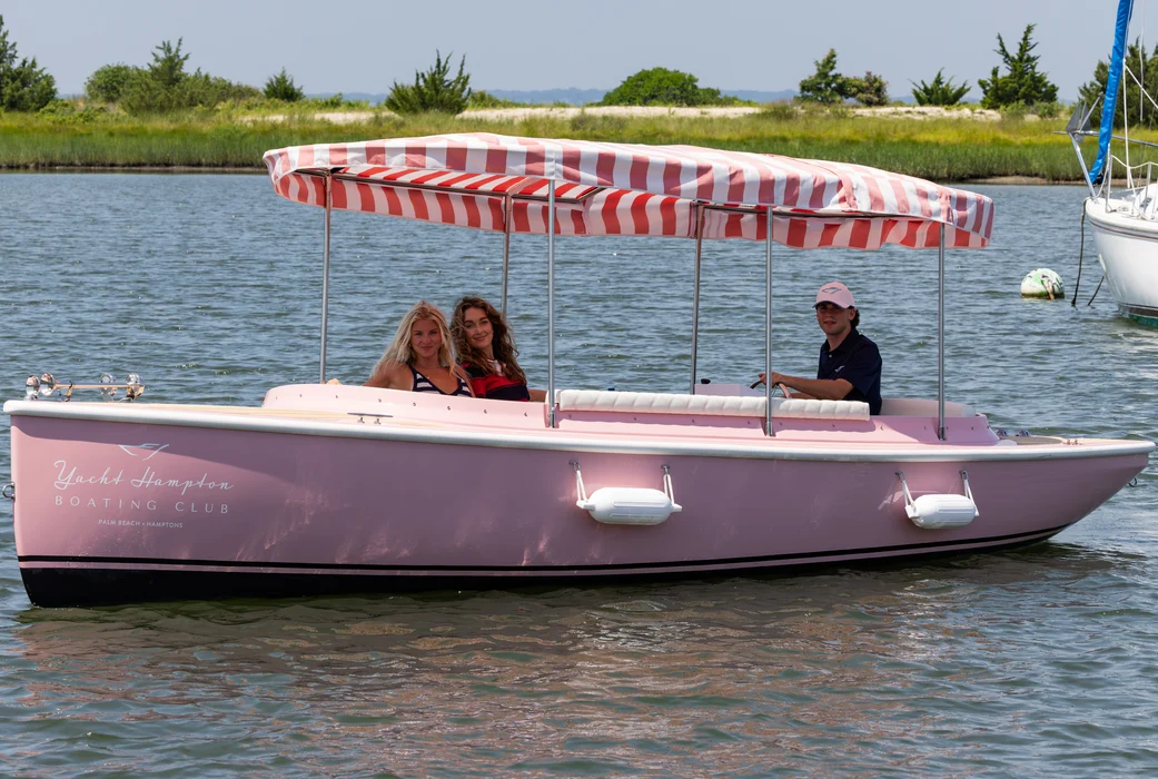 Family enjoying pastel boat rental with striped canopy.