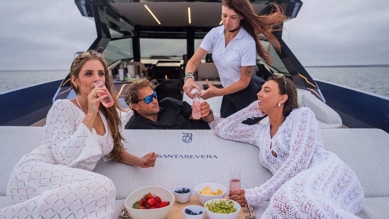 Friends celebrating birthday with drinks aboard luxury yacht.