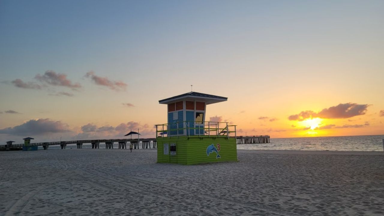  Pompano Beach lifeguard tower at sunrise near pier. 